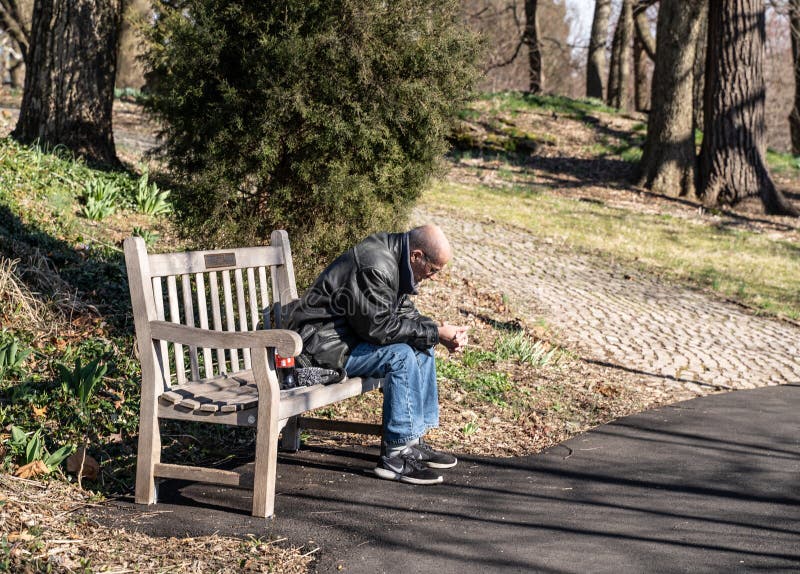 Pessoa idosa sozinha em banco de praça